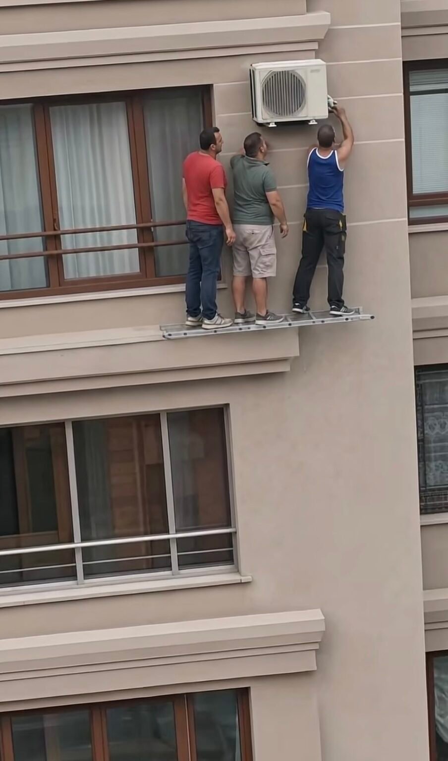 Viral Video of Workers Repairing AC Unit at Height Sparks Safety Debate Viral Video of Workers Repairing AC Unit at Height Sparks Safety Debate