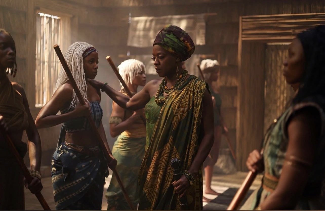 Mama Agba Viola Davis trains young diviner women including Zelie Thuso Mbedu with white braids in staff combat