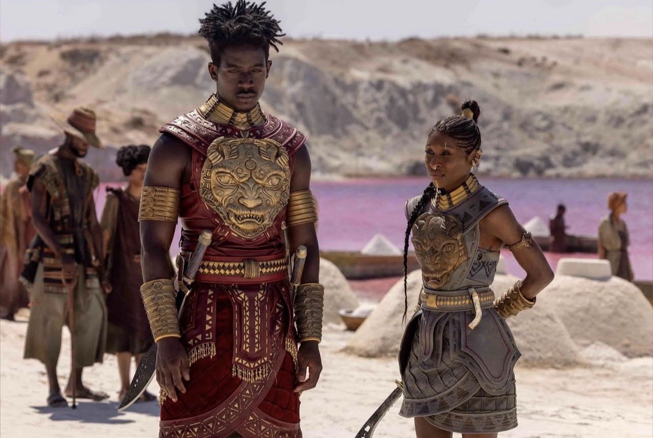 Prince Inan Damson Idris and Admiral Kaea Cynthia Erivo Amandia Stenberg in warrior attire during a desert sequence